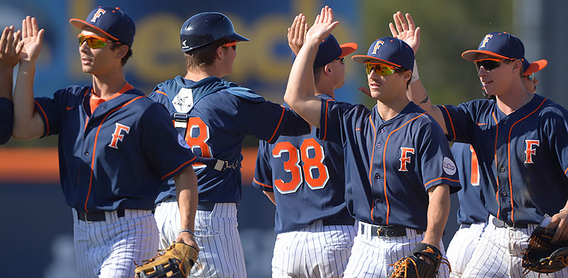 Titan baseball players high five after a win